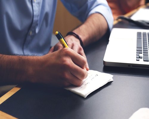 person learning and taking notes in comfortable workspace environment